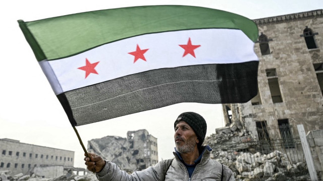 Un homme brandit le drapeau de l'opposition syrienne à la citadelle d'Alep, dans le nord de la Syrie, le 11 décembre 2024.