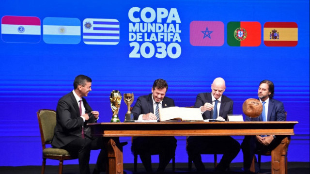 Le président de la Conmebol, Alejandro Dominguez (2e à gauche), et le président de la FIFA, Gianni Infantino (2e à droite), accompagnés du président du Paraguay, Santiago Peña (à gauche), et du président de l'Uruguay, Luis Lacalle (à droite), signent un livre des minutes de la Coupe du monde 2030 lors du 78e Congrès ordinaire de la Conmebol à Luque, au Paraguay, le 11 avril 2024.  