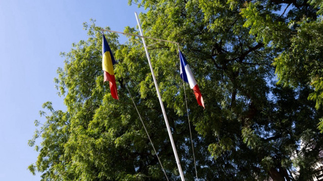 Un drapeau tchadien et un drapeau français sont affichés devant la "Maison des combattants" à côté du marché central de N'Djamena, le 5 décembre 2024. Le président tchadien a déclaré que son pays n'envisageait pas de se tourner vers un autre allié étranger après avoir rompu sa coopération militaire avec la France, à un moment où d'autres États de la région renforcent leurs liens avec la Russie.