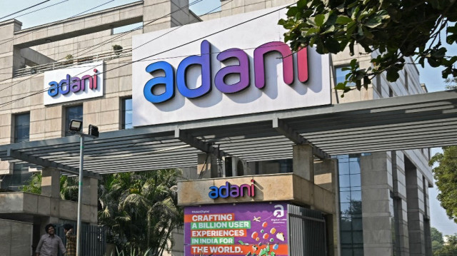 Des piétons passent devant le bâtiment de l'entreprise “Adani House" à Gurgaon en Inde, le 27 novembre 2024. 