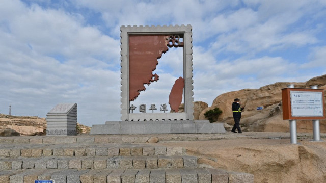 Un membre du personnel de sécurité se trouve sur l'île de Pingtan, le point le plus proche de l'île principale de Taïwan, dans la province chinoise du Fujian (sud-est), dans un site pittoresque appelé "68 Nautical Miles" (68 milles nautiques), le 10 décembre 2024.