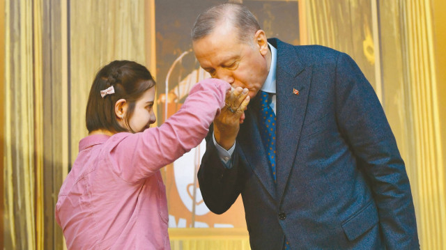 Cumhurbaşkanı Erdoğan, gençlik buluşmasında elini öpen bir kız çocuğunun aynı şekilde elini öptü.