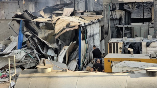 Des Palestiniens inspectent les dégâts causés par une frappe israélienne à l'extérieur de l'hôpital Kamal Adwan, situé à Beit Lahia, dans le nord de la Bande de Gaza.