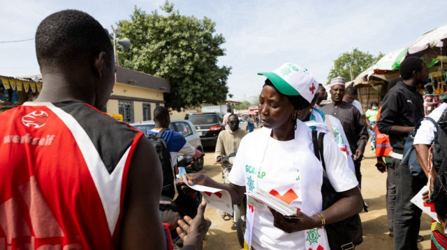 Un membre du Groupe de concertation des acteurs politiques (GCAP) distribue des tracts au marché Dembe pour promouvoir le boycott des élections législatives, communales et provinciales du Tchad à N'Djamena le 16 décembre 2024. 