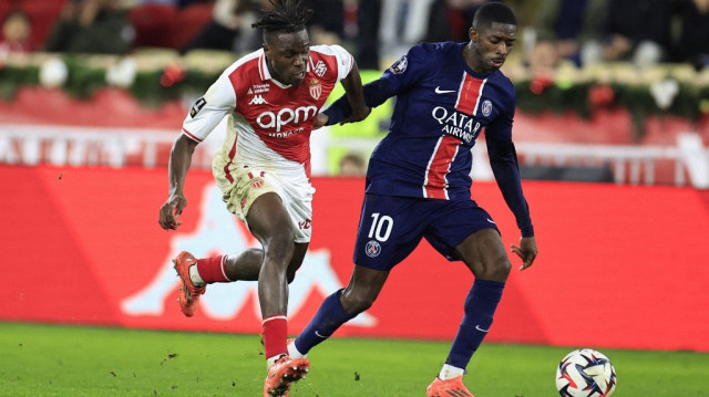 Le défenseur ivoirien de Monaco Wilfried Singo (G), lutte pour le ballon avec l'attaquant français du Paris Saint-Germain Ousmane Dembélé, lors du match de Ligue 1 entre l'AS Monaco et le Paris Saint-Germain au stade Louis-II, dans la Principauté de Monaco, le 18 décembre 2024.