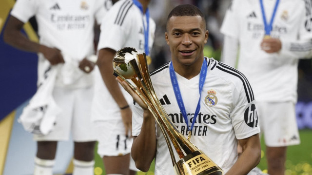 L'attaquant français du Real Madrid, Kylian Mbappé, pose avec le trophée de la Coupe intercontinentale, au stade Lusail de Doha, le 18 décembre 2024.