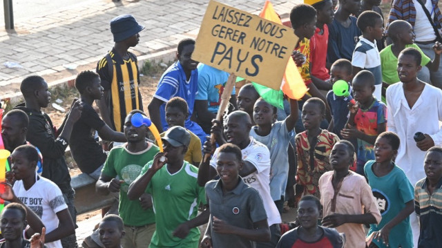 Des partisans du Conseil national pour la sauvegarde de la patrie (CNSP) du Niger tiennent une pancarte sur laquelle on peut lire "Laissez-nous gérer notre pays" devant la base aérienne nigérienne et française à Niamey, le 10 septembre 2023.