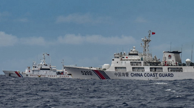 Un navire des gardes-côtes chinois (à droite) passe devant le navire des gardes-côtes philippins BRP Cape Engaño (à gauche) au Sabina Shoal dans les eaux contestées de la mer de Chine méridionale, le 26 août 2024.