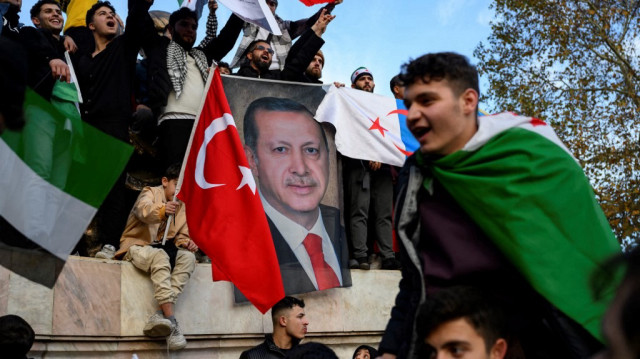 Des personnes tiennent une bannière à l'effigie du président turc Recep Tayyip Erdogan alors que des membres de la communauté syrienne et des sympathisants se rassemblent pour célébrer la chute du président syrien Bachar al-Assad face à l'offensive des rebelles, à Istanbul, le 8 décembre 2024. 