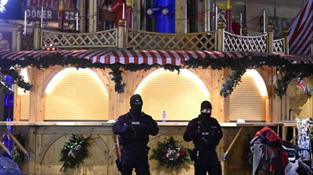 Des membres des forces de sécurité montent la garde à l'entrée d'un marché de Noël où une voiture a foncé dans la foule, blessant plus de 60 personnes, le 21 décembre 2024 à Magdebourg, dans l'est de l'Allemagne. 