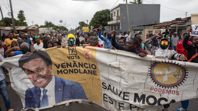 Des manifestants tiennent une banderole avec le portrait du candidat à la présidence du Parti optimiste pour le développement du Mozambique (PODEMOS) Venancio Mondlane, lors d'une manifestation à Maputo, le 7 novembre 2024. Les tensions ont augmenté le 7 novembre 2024 dans la capitale du Mozambique, Maputo, alors que la police a tiré des gaz lacrymogènes pour disperser les manifestants rassemblés après que le principal leader de l'opposition ait appelé à manifester les résultats des élections.