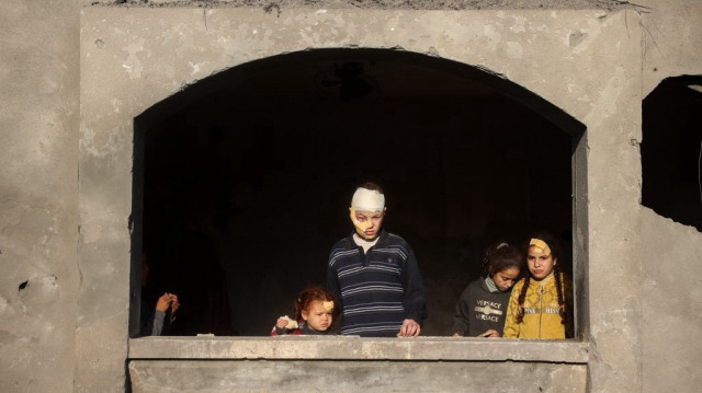 Des enfants blessés regardent à l'intérieur d'un bâtiment endommagé sur le site d'une frappe israélienne qui a visé la maison de la famille Abu Samra à Deir el-Balah dans le centre de la bande de Gaza le 22 décembre 2024.