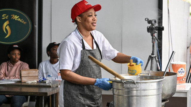 Mélanie Céline Zeinab Bance, la cheffe ivoirienne qui vise le record du monde Guinness avec un marathon culinaire du 17 au 22 décembre 2024, cuisine devant un public venu l'encourager à l'Agora de Koumassi, une commune populaire d'Abidjan, le 22 décembre 2024. 