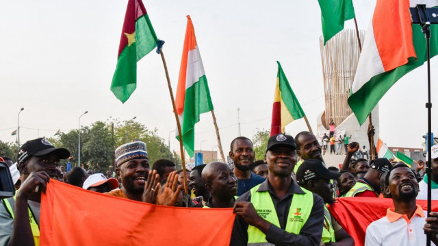 Des partisans de l'Alliance des Etats du Sahel (AES) brandissent des drapeaux alors qu'ils célèbrent le départ du Mali, du Burkina Faso et du Niger de la Communauté économique des Etats de l'Afrique de l'Ouest (CEDEAO) à Niamey, le 28 janvier 2024. 