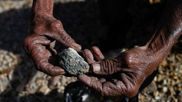 Un mineur artisanal tient le minerai extrait de la mine abandonnée de San Sebastian à Santa Rosa de Lima, dans le département de La Union, au Salvador, le 5 décembre 2024. 