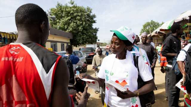 Un membre du Groupe de concertation des acteurs politiques (GCAP) distribue des tracts au marché Dembe pour promouvoir le boycott des élections législatives, communales et provinciales du Tchad à N'Djamena le 16 décembre 2024. 