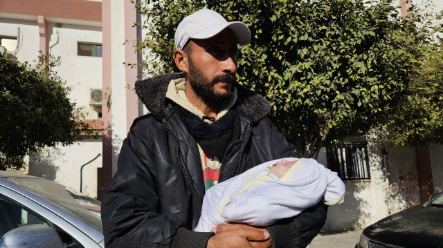 Un palestinien tient son enfant mort de froid à Khan Younes, dans le sud de la Bande de Gaza, le 25 décembre 2024.