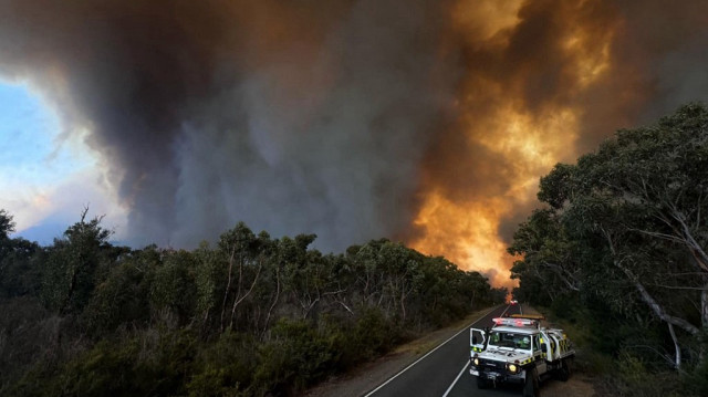 Des fonctionnaires sur une route près d'un feu de brousse dans le parc national des Grampians dans l'État de Victoria en Australie, le 26 décembre 2024.