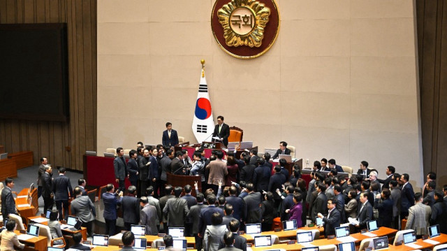 Les législateurs du Parti du pouvoir du peuple de Corée du Sud (en bas) discutent avec le président de l'Assemblée nationale Woo Won-shik (en haut) lors de la session plénière pour le vote de destitution du président en exercice Han Duck-soo à l'Assemblée nationale à Séoul, le 27 décembre 2024.