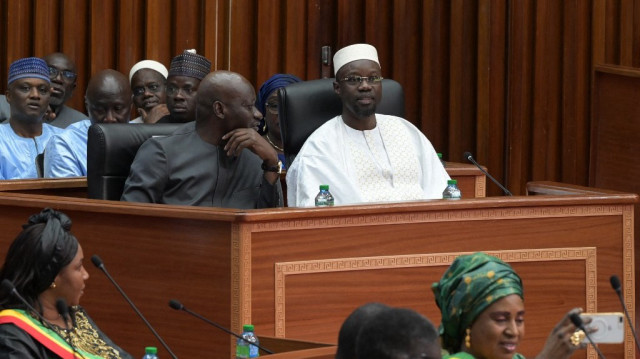 Le Premier ministre sénégalais Ousmane Sonko (à droite) attend de prononcer son discours de politique générale à l'Assemblée nationale, à Dakar, le 27 décembre 2024.