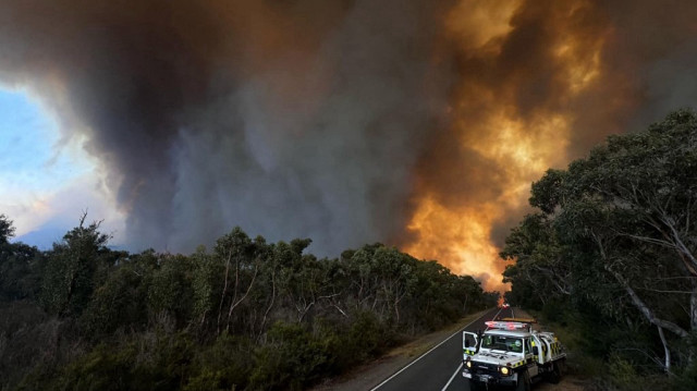 Des fonctionnaires sur une route près d'un feu de brousse dans le parc national des Grampians dans l'État de Victoria en Australie, le 26 décembre 2024.