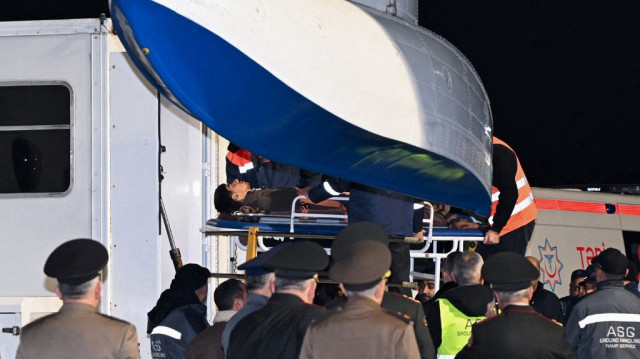 Le personnel au sol et les médecins de l'aéroport assistent les citoyens azerbaïdjanais qui ont survécu au crash de l'Embraer 190 d'Azerbaijan Airlines, à leur arrivée à l'aéroport international Heydar Aliyev de Bakou, le 26 décembre 2024.