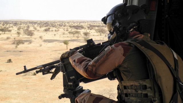 Un soldat français de la mission Barkhane dans la région africaine du Sahel, pointe une mitrailleuse depuis un hélicoptère NH90 entre Gao et Menaka, au Mali, le 21 mars 2019.
