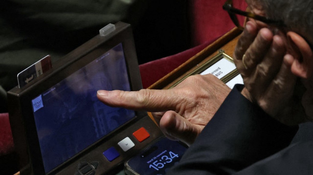 Un sénateur vote lors d'une séance d'examen sénatorial du Projet de loi de financement de la sécurité sociale (PLFSS) pour 2025, au Sénat français, à Paris, le 26 novembre 2024.