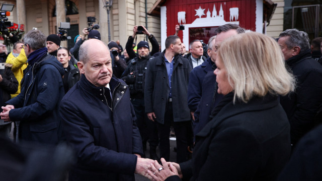 Le chancelier allemand Olaf Scholz (au centre) et la ministre allemande de l'Intérieur Nancy Faeser (à droite) se serrent la main lors d'une visite sur le site de l'attentat contre un marché de Noël à Magdebourg, le 21 décembre 2024.