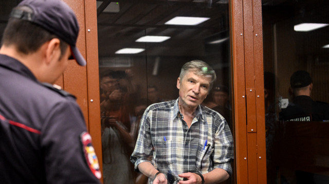 Le député de Moscou Alexei Gorinov, se tenant à l'intérieur d'une cellule en verre lors de l'audience du verdict de son procès au palais de justice de Moscou, le 8 juillet 2022.