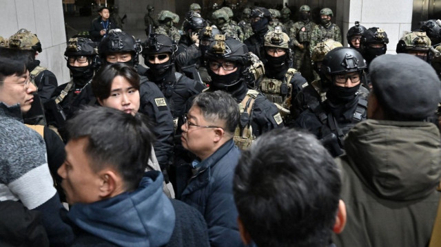 Des soldats tentent d'entrer dans le bâtiment de l'Assemblée nationale à Séoul le 4 décembre 2024, après que le président sud-coréen Yoon Suk Yeol a déclaré la loi martiale. 