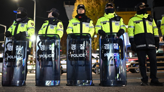 La police surveille les manifestants qui participent à une marche contre le président sud-coréen Yoon Suk Yeol en direction du bureau présidentiel à Séoul, le 4 décembre 2024.