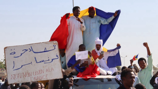 Des manifestants brandissent des drapeaux tchadiens lors d'une manifestation contre la France à N'djamena, le 6 décembre 2024.