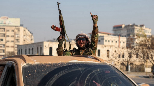 Un combattant anti-gouvernemental fait un geste à l'intérieur d'un véhicule patrouillant dans les rues de Hama après la prise de la ville centrale syrienne, le 6 décembre 2024.