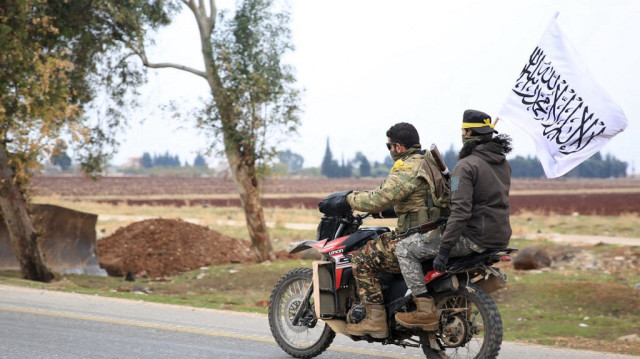 Les forces anti-gouvernementales conduisent dans la ville d'al-Rastan dans la province de Homs, au centre-ouest de la Syrie, le 7 décembre 2024, sur leur chemin vers la ville de Homs.