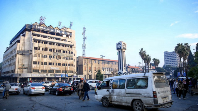 Des Syriens se rassemblent pour célébrer la Tour de l'Horloge dans la ville centrale de Homs, le 8 décembre 2024, après que les forces rebelles soient entrées dans la troisième ville de Syrie pendant la nuit.