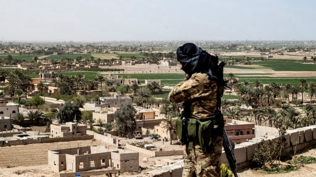 Un combattant des Forces démocratiques syriennes (FDS) dirigées par les Kurdes monte la garde au sommet d'une colline surplombant le village de Baghouz, dans la province de Deir Ezzor, le 24 mars 2021.