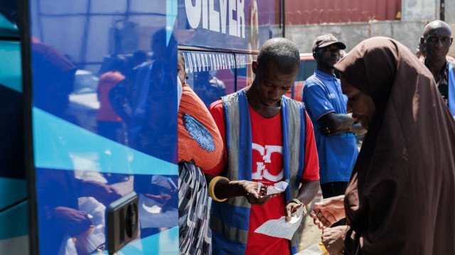 Des voyageurs montent à bord d'un bus en direction du nord du Nigéria avant les fêtes de fin d'année, à la gare routière d'Iddo, à Lagos, le 18 décembre 2023.