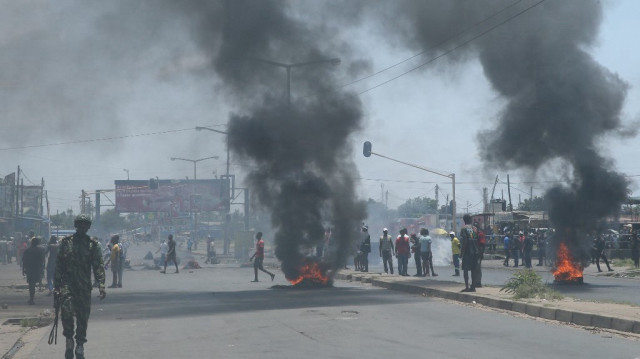 Un soldat mozambicain s'éloigne alors que des manifestants brûlent des pneus lors d'une manifestation contre le gouvernement à Maputo, le 6 décembre 2024.