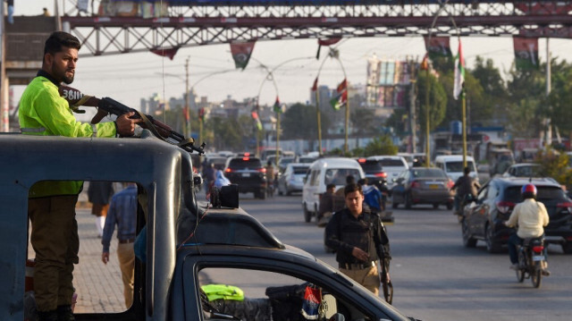 Les policiers tiennent la garde le long d'une rue de Karachi le 1er février 2024, avant les élections générales.