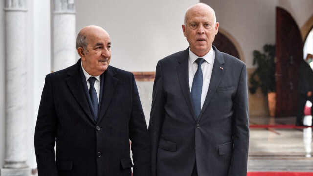 Le président tunisien Kais Saied (à droite) marche avec le président algérien Abdelmajid Tebboune (à gauche) à l'arrivée de ce dernier à l'aéroport international de Tunis-Carthage desservant la capitale tunisienne, le 15 décembre 2021. 