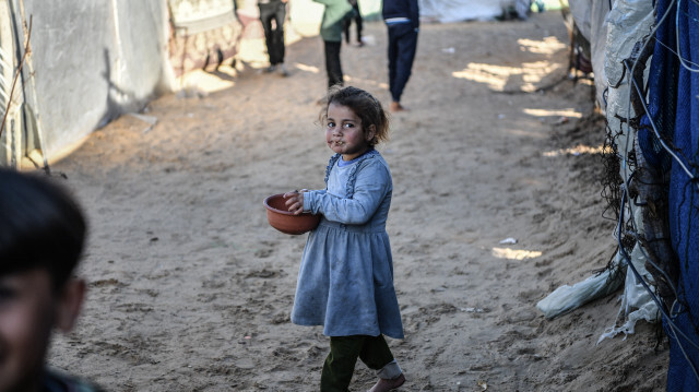 Une jeune fille palestinienne marche près des tentes de fortune alors que les familles palestiniennes cherchent refuge dans le quartier d'El-Mavasi, le 9 février 2024.