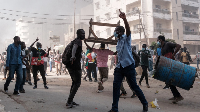 Des manifestants criant des slogans et ramassant des barils et des tables à brûler lors d'affrontements avec la police en marge d'une manifestation contre le report de dernière minute des élections présidentielles à Dakar, le 9 février 2024. 