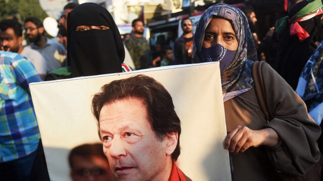 Des partisans du parti Pakistan Tehreek-e-Insaf (PTI) tenant une photo de l'ancien premier ministre emprisonné Imran Khan lors d'une manifestation devant un bureau de la commission électorale à Karachi, le 10 février 2024.