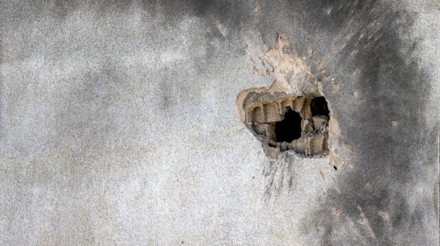 Cette photo prise le 11 février 2024 montre un trou dans le mur d'un bâtiment dans la ville de Kiryat Shmona, au nord d'Israël, près de la frontière avec le Liban, après l'impact d'une roquette tirée depuis l'autre côté de la frontière.