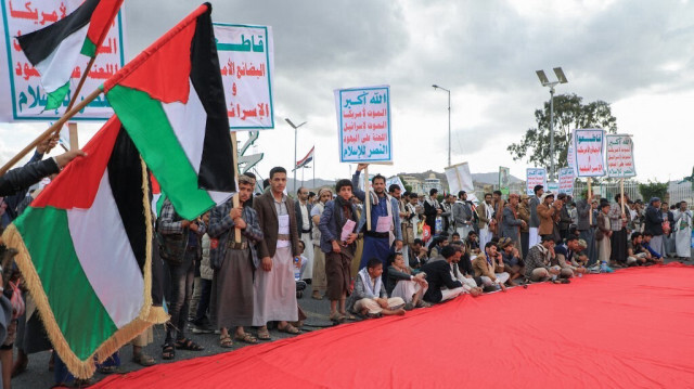 Des manifestants se rassemblent autour d'un drapeau palestinien géant lors d'un rassemblement à Sanaa, la capitale dirigée par les Huthis, le 9 février 2024.