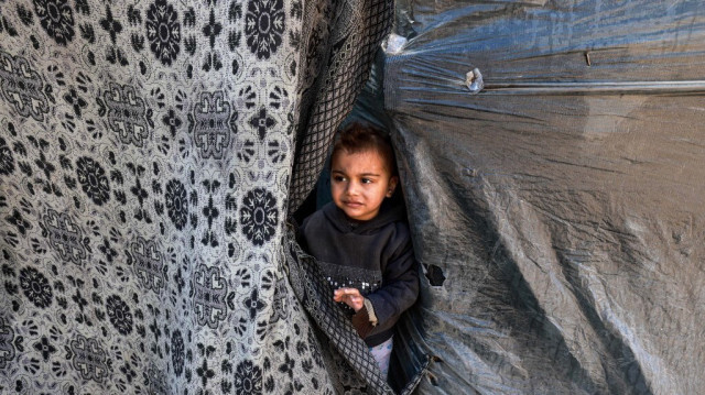 Un enfant Palestinien s'abritant dans une tente, déplacé de force par les bombardements de l'armée d'occupation israélienne, à Rafah, dans le sud de la Bande de Gaza, le 8 février 2024.