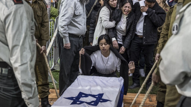 Membres de la famille du soldat israélo-philippin Cedric Green, l'un des 21 soldats tués dans la bande de Gaza le 23 janvier, se rassemblent autour de son cercueil lors de ses funérailles au cimetière de Kiryat Shaul à Tel Aviv le 25 janvier 2024.