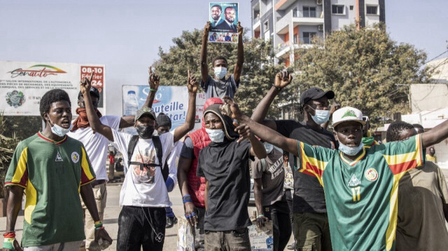 Des manifestants brandissent des pierres et des portraits du chef de l'opposition sénégalaise, Ousmane Sonko, lors d'affrontements avec la police à Dakar, le 9 février 2024. 