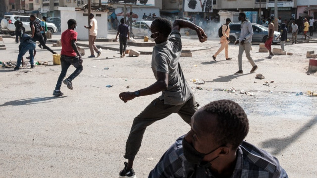 Un manifestant jette des pierres lors d'affrontements avec la police en marge d'une manifestation contre le report à la dernière minute de l'élection présidentielle, à Dakar, le 9 février 2024.